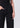 Person wearing black jeans on a plain background