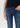 Person wearing blue jeans on a plain background
