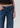 Person wearing blue jeans on a plain background