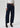 Person wearing dark blue jeans and black boots on a white background