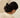 Person with a black scrunchie in their hair against a beige background