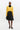 Woman wearing a yellow sweater and black skirt on a white background