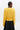 Person wearing a yellow sweater and black skirt on a white background