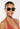 Woman wearing sunglasses and a red halter top against a white background