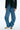 Person wearing blue jeans and a black jacket on a white background