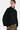Person wearing a black sweater with a white background
