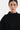 Person wearing a black turtleneck sweater with fringe details on a white background
