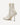 White ankle boot with a gold zipper on a white background