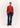 Person wearing a red cardigan and black pants on a white background